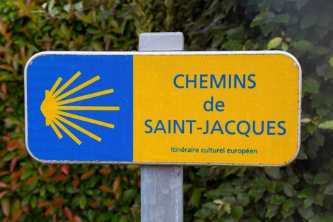 A signpost for the Chemins de Saint-Jacques, yellow-blue with scallop shell symbol, Way of St