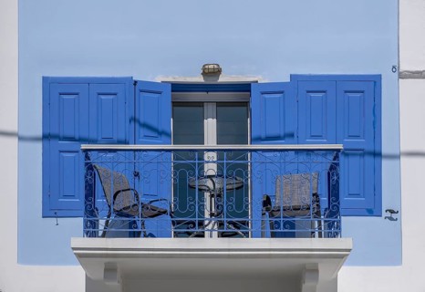 Balcony on a white house, blue door and window shutters, Symi Island, Dodecanese, Greek Islands,