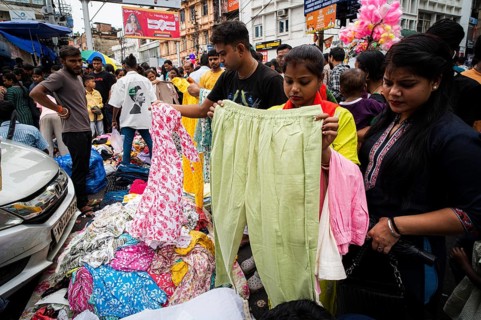 People buys clothes at a street market ahead of Durga Puja festival on October 7, 2024 in Guwahati,