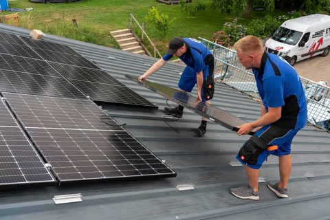 Installation of solar modules on the roof of a barn on a farm, over 240 photovoltaic modules are