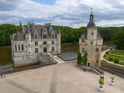 Renaissance castle with separate tower and moat, directly on the river and surrounded by greenery,