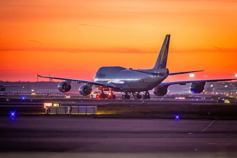 Early in the morning in front of sunrise at the airport, a jumbo jet stands ready for take-off on