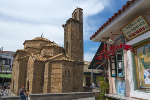 Byzantine church next to a snack shop with people walking around, Church of the Apostles, Agii