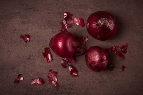 Red onion, fresh, raw, on a dark background, top view