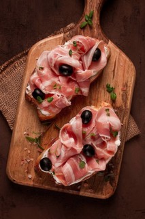 Breakfast, bacon and olives sandwich, on a cutting board, top view, close-up, no people