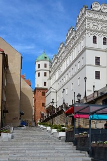 View of a historic building facade with a staircase under a blue sky with clouds, Castle of the