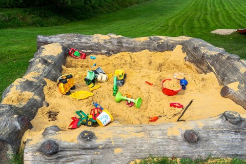 Sandpit, on a children's playground, sandpit with various plastic toys, excavator, shovels, moulds