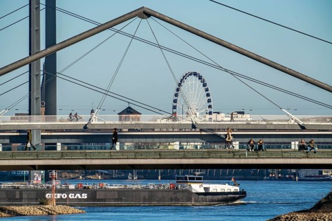 Pedestrian bridge over the Media Harbour, Ferris wheel in the old town, cargo ship on the Rhine,
