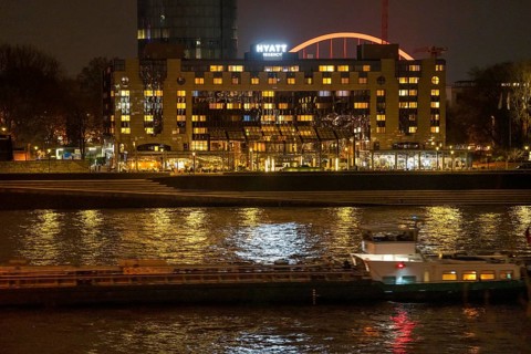 The Hyatt Regency Hotel on the Rhine, in Cologne Deutz, behind it the illuminated arch of the