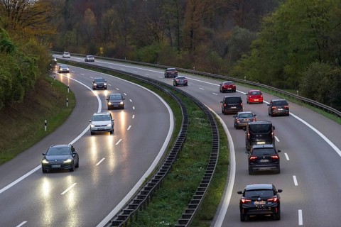 Motorway with several cars at dusk, headlights switched on, surrounded by trees, Rems-Murr