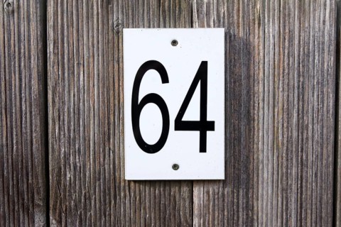 64, number, sixty-four, sign, The numbers 6 and 4 are written in black numbers on a white sign. The
