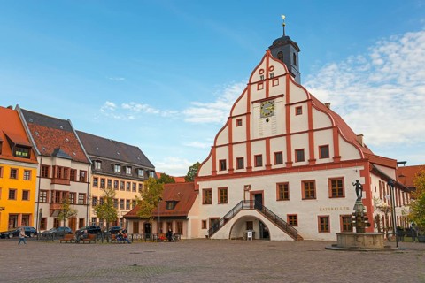 Historic town hall with clock tower on a cobbled square under a blue sky in an old town, town hall,