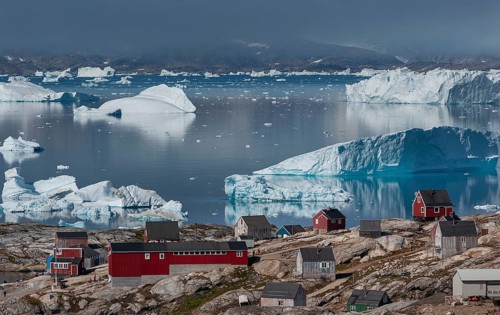 Large icebergs floating in fjord behind Inuit settlement Tiniteqilaaq, Sermilik Fjord, East