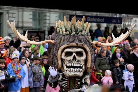 Person masked as a skull with antlers at the carnival parade of the Wey guild on Rose Monday,