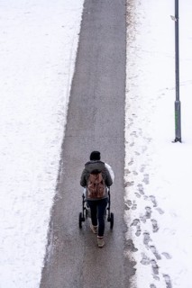 Winter in the city, cleared riverside path on the Main, woman with pram, Frankfurt, Hesse, Germany,