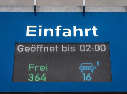 Display board at a public car park, showing free parking spaces for electric cars, North