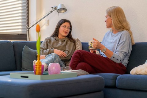 Mother and daughter, teenage, 13 years old, in a confidential conversation, at home