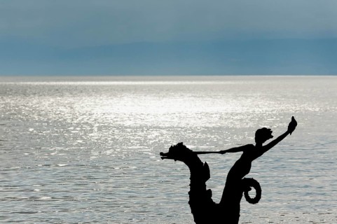 Sculpture with mermaid against the light on the promenade in Vevey on Lake Geneva, Vaud,