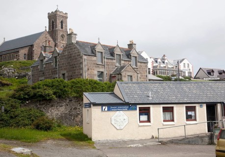 Tourist Information office, houses, hotel and church in Castlebay, Barra, Outer Hebrides, Scotland,