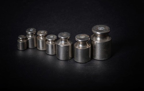 A set of small metal weights on a gray background