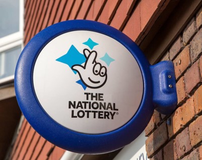 Wall mounted sign for the National Lottery, Amesbury, Wiltshire, England, UK