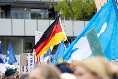 A German flag between peace flags at the Die Waffen nieder demonstration on Breitscheidplatz in