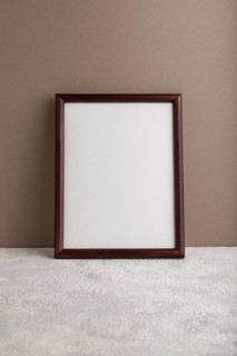 Brown wooden frame mockup on beige paper background. Blank, vertical orientation, still life, copy