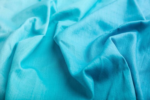Fragment of cotton blue tissue. Side view, natural textile background and texture. wave concept,