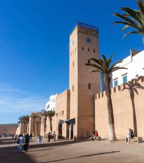 People walking outside medina walls, L'Horloge d'Essaouira, Essaouira, Morocco, north Africa,