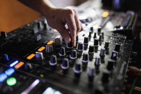 A DJ plays on a mixer and two Cdjs in Berlin, 14/08/2024