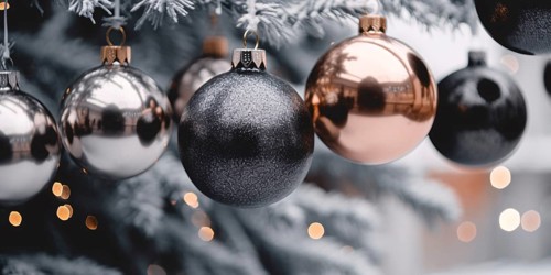 Banner with elegant black and golden Christmas tree bauble ornaments on snow covered tree. KI