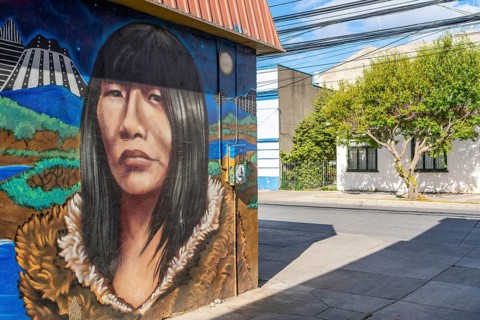 Colourful graffito with the image of an indigenous woman, street art in the city of Punta Arenas,