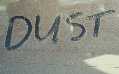 The word 'DUST' written on car rear windscreen following Saharan sand deposited in England by