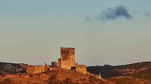 An old castle ruin under a sky with sunset, reflecting the silence of the surroundings, a