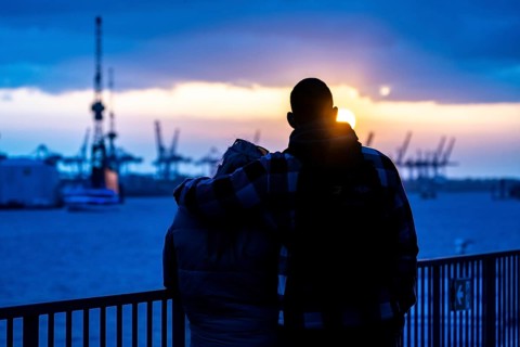 Port of Hamburg, couple looking at the Blohm + Voss shipyard, evening, cranes of the container