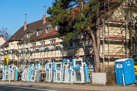 Energy-efficient refurbishment of residential buildings, older apartment block is scaffolded, gets