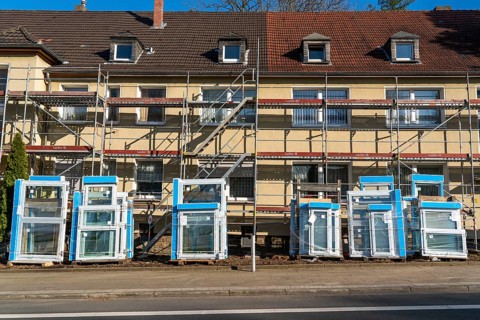 Energy-efficient refurbishment of residential buildings, older apartment block is scaffolded, gets
