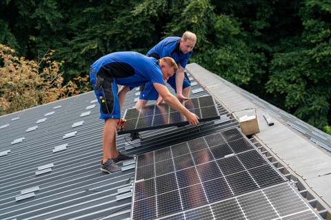 Installation of solar modules on the roof of a barn on a farm, over 240 photovoltaic modules are
