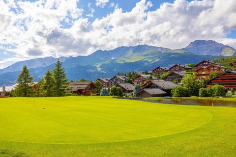Crans Sur Sierre Golf Course with House and Mountain View in Crans Montana in Valais, Switzerland,