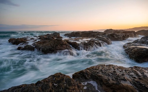Waves washing over rocks by the sea, long exposure, coastal landscape at sunset, Playa Cocalito,