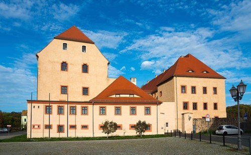 Medieval castle with tiled roof and many windows under a blue sky on a sunny day, castle, today