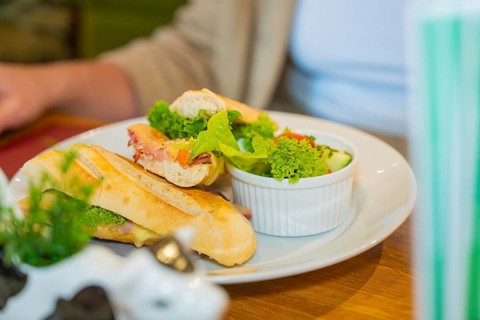 A fresh sandwich on ciabatta bread with salad, served on a white plate, autumn creations, Cafe Kuh,