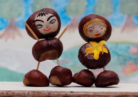 Two cute chestnut figures in front of a painted background, North Rhine-Westphalia, Germany, Europe