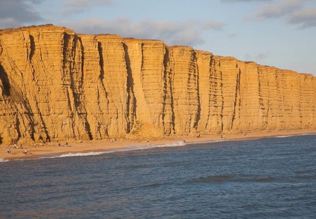Golden afternoon light on sandstone cliffs, East Cliffs, West Bay, Bridport, Dorset, England, UK
