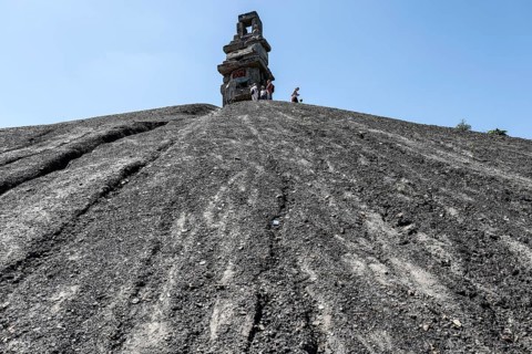 E-bikers cycle to the Rheinelbe spoil tip in Gelsenkirchen. The Himmelstreppe sculpture stands on