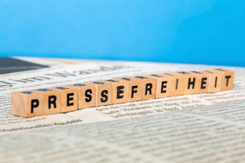 Symbolic image of press freedom: letter cube on a newspaper