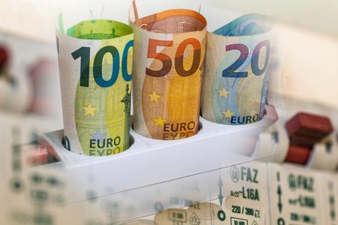 Symbolic image of electricity costs: euro banknotes in a multiple socket and a distribution box