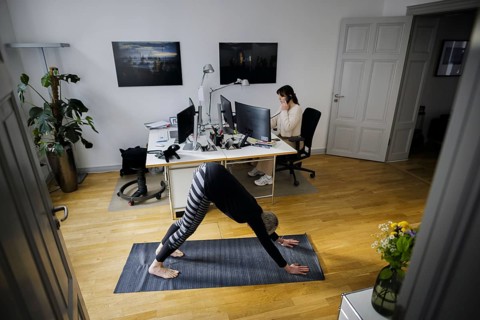 Symbolic photo on the subject of occupational health management. A woman exercises on a sports mat