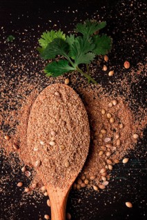Fresh cilantro, coriander grains and powder, on a wooden table, top view, no people