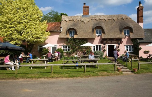 People sitting outside the Sorrel Horse thatched village pub, Shottisham, Suffolk, England, United
